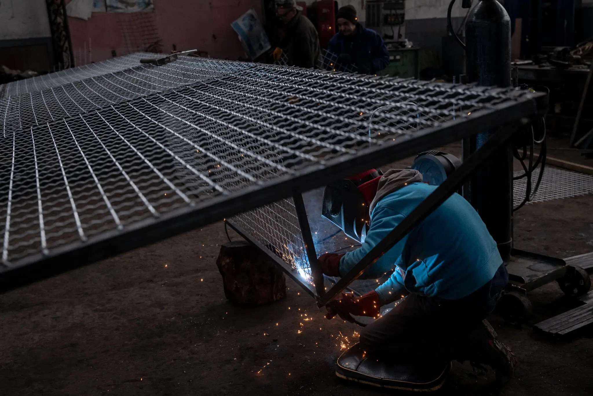 Механік зварює металеву клітку, яка використовується для захисту великих транспортних засобів під час атак безпілотників.